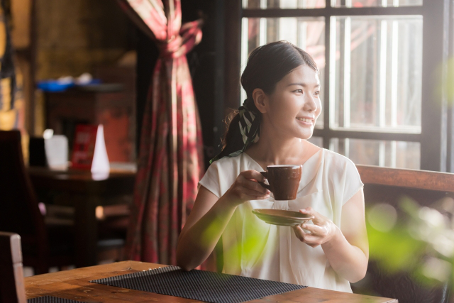 カフェで一人でコーヒーを飲んでいる女性